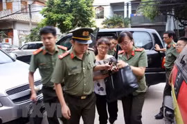 Cơ quan an ninh đưa bà Nguyễn Thị Hồng Nga, chuyên viên phòng Khảo thí và Quản lý chất lượng, Sở Giáo dục và Đào tạo tỉnh Sơn La, thư ký Ban chỉ đạo, ủy viên tổ chấm thi trắc nghiệm về nhà riêng để kiểm tra, khám xét. (Ảnh: Hữu Quyết/TTXVN)