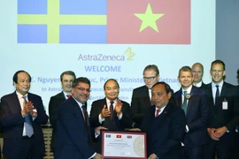 Thủ tướng Nguyễn Xuân Phúc chứng kiến Lễ trao biểu trưng cam kết đầu tư của AstraZeneca tại Việt Nam. (Ảnh: Thống Nhất/TTXVN)
