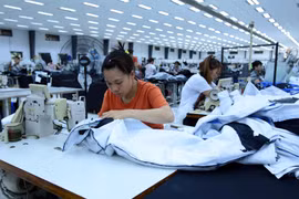 Công nhân sản xuất hàng may mặc tại Công ty trách nhiệm hữu hạn Kydo Việt Nam. (Ảnh: Phạm Kiên/TTXVN)
