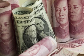 Đồng nhân dân tệ và đồng USD tại một ngân hàng ở Bắc Kinh, Trung Quốc. (Nguồn: AFP/TTXVN)