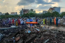 Thi thể nạn nhân được đưa khỏi hiện trường. (Nguồn: TTXVN phát)