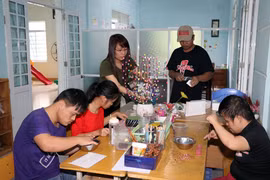 Cô Trần Thị Diệp hướng dẫn các em làm hoa voan. (Ảnh: Trần Lê Lâm/Vietnam+)