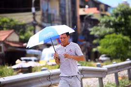 Ô là dụng cụ tránh nắng không thể thiếu đối với người đi bộ mỗi khi có việc phải di chuyển ngoài đường. (Ảnh: Quang Quyết/TTXVN)