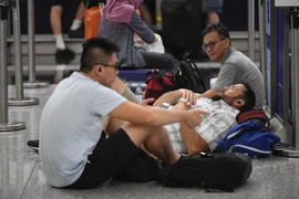 Hành khách chờ đợi tại sân bay quốc tế Hong Kong, Trung Quốc, ngày 12/8. (Nguồn: THX/TTXVN)