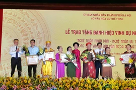 Lãnh đạo thành phố Hà Nội trao tặng danh hiệu vinh dự Nhà nước cho các nghệ nhân nhân dân. (Ảnh: Đinh Thuận/TTXVN)