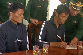 Hai ngư dân Philippines được Bội đội biên phòng tỉnh Bình Định hướng dẫn làm các thủ tục .(Ảnh: Quốc Dũng/TTXVN)