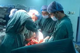 Êkíp bác sỹ đang phẫu thuật cấp cứu cho sản phụ Phạm Thị H. (Ảnh: Lê Xuân/TTXVN)