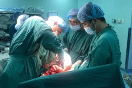 Êkíp bác sỹ đang phẫu thuật cấp cứu cho sản phụ Phạm Thị H. (Ảnh: Lê Xuân/TTXVN)