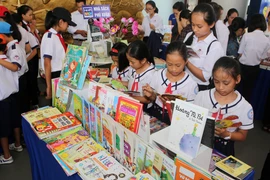 Học sinh huyện Quảng Điền (Thừa Thiên-Huế) tham quan triển lãm và đọc sách trong Ngày sách Việt Nam. (Ảnh: Hồ Cầu/TTXVN)