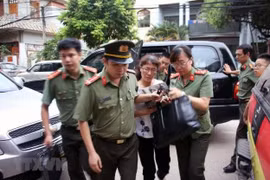 Cơ quan an ninh đưa bà Nguyễn Thị Hồng Nga, chuyên viên phòng Khảo thí và Quản lý chất lượng, Sở Giáo dục và Đào tạo tỉnh Sơn La, thư ký Ban chỉ đạo, ủy viên tổ chấm thi trắc nghiệm về nhà riêng để kiểm tra, khám xét. (Ảnh: Hữu Quyết/TTXVN)