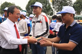 Ông Trần Văn Nam, Ủy viên Trung ương Đảng, Bí thư Tỉnh ủy Bình Dương, động viên, tặng quà cho các công nhân về quê ăn Tết. (Ảnh: Hải Âu/TTXVN)
