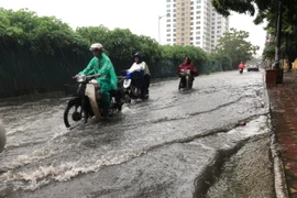 Mưa to gây ngập úng cục bộ trên phố Lương Thế Vinh. (Ảnh: Huy Hùng/TTXVN)