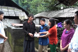 Lãnh đạo Phòng Lao động, Thương binh và Xã hội huyện Mèo Vạc thăm hỏi, trao số tiền 6,4 triệu đồng hỗ trợ cho gia đình có nạn nhân tử vong do sét đánh. (Ảnh: Minh Tâm/TTXVN)