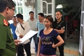 Đối tượng Trần Thị Hiền nghe công bố Quyết định khởi tố và Lệnh bắt tạm giam của cơ quan điều tra. (Ảnh: Xuân Tiến/TTXVN)
