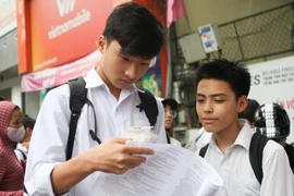 Thí sinh trao đổi bài sau khi hoàn thành hai môn thi cuối tại điểm thi trung học phổ thông Việt Đức, Hà Nội. (Ảnh: Thanh Tùng/TTXVN)