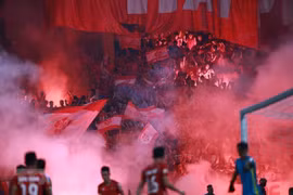 Khói mù mịt sân Hàng Đẫy do cổ động viên Hải Phòng đốt pháo sáng trên khán đài, khiến trọng tài phải thổi còi gián đoạn trận đấu ít phút. (Ảnh: Trọng Đạt/TTXVN)
