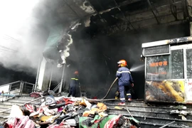 Lực lượng chức năng nỗ lực dập tắt đám cháy. (Ảnh: Thu Hằng/TTXVN)