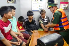 Cán bộ quân y thăm khám, kiểm tra tình hình sức khỏe 6 ngư dân và 2 cháu bé. (Ảnh: Võ Dung/TTXVN)