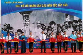Các vị lãnh đạo tỉnh Sơn La và lãnh đạo Ban Quản lý Di tích Chủ tịch Hồ Chí Minh cắt băng khai mạc triển lãm ảnh 'Bác Hồ với nhân dân các dân tộc Tây Bắc.' (Ảnh: Nguyễn Cường/TTXVN)