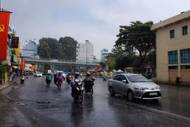 Người dân lưu thông trong mưa trên đường Thành Thái, Quận 10. (Ảnh: Xuân Dự/TTXVN)