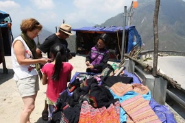 Du khách tham quan mua sắm trên đỉnh đèo Ô Quy Hồ, thị trấn Sapa, tỉnh Lào Cai. (Ảnh: Thanh Vũ/TTXVN)