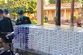 Các chiến sỹ thuộc Đồn Biên phòng cửa khẩu quốc tế Xa Mát kiểm đếm số thuốc lá điếu ngoại nhập lậu vừa thu giữ. (Ảnh: Thanh Tân/TTXVN)