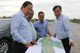 Phó Chủ tịch UBND tỉnh Long An Nguyễn Minh Lâm (trái) xem bản đồ đường Vành đai 3 Thành phố Hồ Chí Minh qua địa bàn tỉnh. (Ảnh: Thanh Bình/TTXVN)
