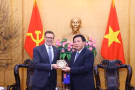 Giám đốc Học viện Chính trị quốc gia Hồ Chí Minh Nguyễn Xuân Thắng tặng quà lưu niệm cho Đại sứ Australia tại Việt Nam Andrew Goledzinowski. (Ảnh: Văn Điệp/TTXVN)