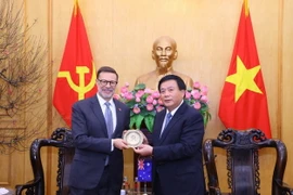 Giám đốc Học viện Chính trị quốc gia Hồ Chí Minh Nguyễn Xuân Thắng tặng quà lưu niệm cho Đại sứ Australia tại Việt Nam Andrew Goledzinowski. (Ảnh: Văn Điệp/TTXVN)