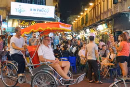 Ngồi trên xích lô, hít thở khí trời trong lành, chậm rãi di chuyển qua từng con phố, ngõ hẻm để ngắm trọn những nét văn hóa, hoạt động đời sống thường ngày của người dân Thủ đô đã mang lại những ấn tượng khó phai đối với nhiều du khách quốc tế. (Ảnh: Khán