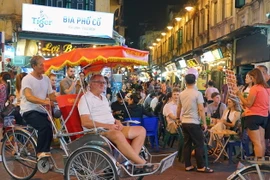 Ngồi trên xích lô, hít thở khí trời trong lành, chậm rãi di chuyển qua từng con phố, ngõ hẻm để ngắm trọn những nét văn hóa, hoạt động đời sống thường ngày của người dân Thủ đô đã mang lại những ấn tượng khó phai đối với nhiều du khách quốc tế. (Ảnh: Khán