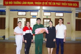 Đại diện Bộ đội Biên phòng Cao Bằng phá chuyên án mua bán người dưới 16 tuổi và bàn giao cháu bé cho cơ quan bảo trợ xã hội địa phương. (Ảnh: Nông Tuấn/TTXVN phát)