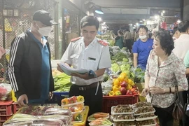 Đoàn kiểm tra Ban Quản lý an toàn thực phẩm Thành phố Hồ Chí Minh kiểm tra rau củ quả tại một chợ đầu mối nông sản trong thành phố. (Ảnh: TTXVN phát)