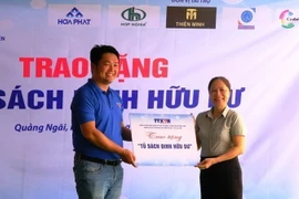 Ban tổ chức trao bảng tượng trưng Tủ sách Đinh Hữu Dư cho Ban giám hiệu Trường. (Ảnh: Đinh Hương/TTXVN)