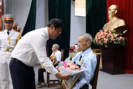 Bí thư Thành ủy Vũng Tàu Trần Đình Khoa tặng hoa cho đảng viên 65 năm tuổi Đảng. (Ảnh: Đoàn Mạnh Dương/TTXVN)