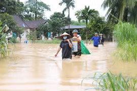 Người dân xã Yên Hợp, huyện Quỳ Hợp, tỉnh Nghệ An, giúp nhau vận chuyển tài sản, đồ đạc để tránh lũ tại các gia đình đã bị ngập nặng. (Ảnh: Xuân Tiến/TTXVN)