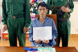 Đối tượng Kháng A Cấu và tang vật vụ án. (Ảnh: TTXVN phát)