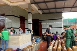 Lực lượng chức năng kiểm tra, thu giữ dầu DO không rõ nguồn gốc. (Ảnh: TTXVN phát)