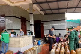 Lực lượng chức năng kiểm tra, thu giữ dầu DO không rõ nguồn gốc. (Ảnh: TTXVN phát)