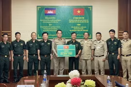 Đại tá Trần Tiến Hải, Chỉ huy trưởng Bộ đội Biên phòng tỉnh Gia Lai trao tặng kinh phí cho các lực lượng bảo vệ biên giới của tỉnh Ratanakiri, Vương quốc Campuchia. (Ảnh: TTXVN phát)