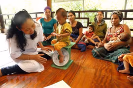 Nhân viên y tế kiểm tra sức khỏe và tư vấn dinh dưỡng trẻ em cho đồng bào dân tộc. (Ảnh: Dương Ngọc/TTXVN)