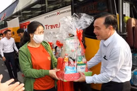 Lãnh đạo Saigon Co.op tặng quà cho người lao động trước khi khởi hành “Chuyến xe hạnh phúc” đưa người lao động về quê ăn Tết. (Ảnh: Thanh Vũ/TTXVN)