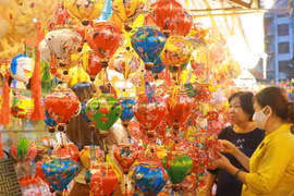 Người dân lựa chọn các mẫu lồng đèn về trang trí cho căn nhà. (Ảnh: Thu Hương/TTXVN)