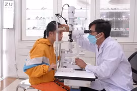 Thạc sỹ-bác sỹ chuyên khoa mắt Nguyễn Hữu Thế, thăm khám cho bệnh nhi đau mắt đỏ. (Ảnh: Minh Phú/TTXVN)