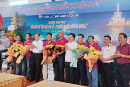 Đại diện Ban Tuyên giáo Thành ủy, Hội Nhà báo Hải Phòng tặng hoa cho các nghệ sỹ nhiếp ảnh có tác phẩm trưng bày. (Ảnh Minh Huệ/TTXVN)