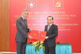 Ông Lê Hoài Trung, Ủy viên Trung ương Đảng, Trưởng Ban Đối ngoại Trung ương và ông Miguel Mejia, Tổng Bí thư Đảng Phong trào cánh tả thống nhất Dominica trao bản thỏa thuận hợp tác giữa hai Đảng. (Ảnh: Phương Hoa/TTXVN)