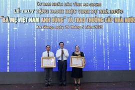 Thừa ủy quyền của Chủ tịch nước, ông Lê Hồng Quang, Bí thư Tỉnh ủy An Giang trao Bằng vinh dự truy tặng Danh hiệu “Bà mẹ Việt Nam Anh hùng” cho thân nhân mẹ Lâm Thị Chính và mẹ Mai Thị Măng. (Ảnh: Thanh Sang/TTXVN)