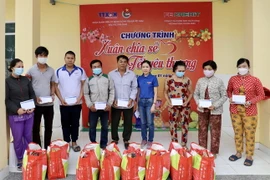 Phó Bí thư Đoàn Thanh niên Cơ quan TTXVN Khu vực phía Nam Bùi Thị Xuân Anh gửi các phần quà Tết cho người dân khó khăn tại huyện Cần Giờ. (Ảnh: Hồng Giang/TTXVN)