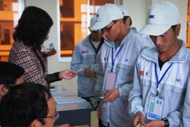 Lao động làm thủ tục trước khi đi làm việc ở nước ngoài. (Ảnh minh họa: PV/Vietnam+)