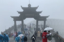 Đông đảo khách du lịch đã lên đỉnh Fansipan để chiêm ngưỡng cảnh tuyết rơi. (Ảnh: Quốc Khánh/TTXVN)